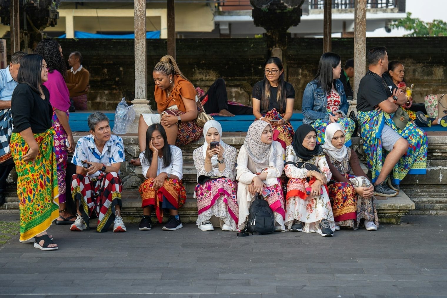 A group of people sitting on a bench next to each other