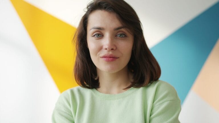 Homepage | curaJOY Young woman in a light green sweater smiles gently.